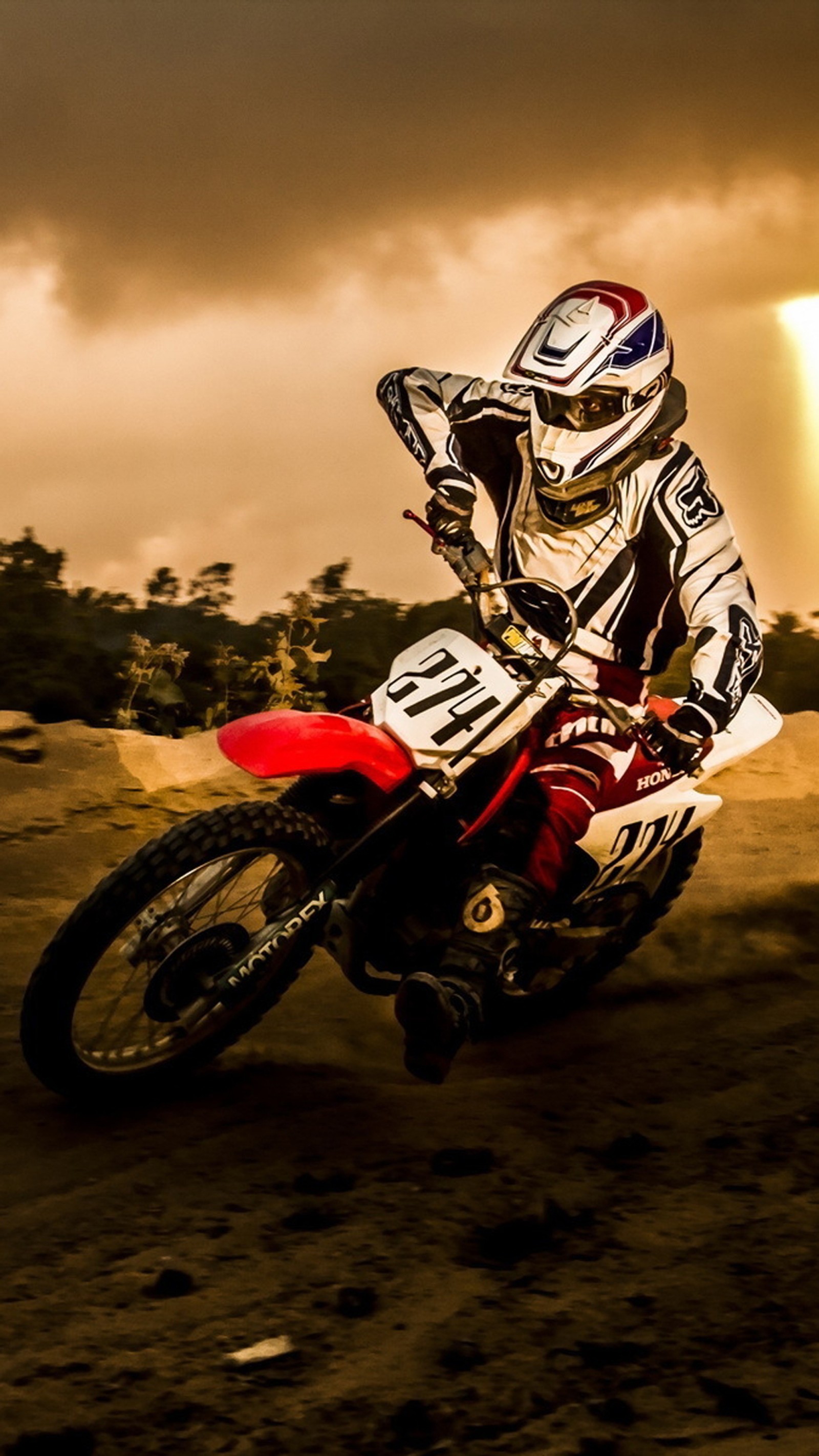 Un motociclista montando una moto de cross en una pista de tierra (bicicleta, honda, barro, offroad, velocidad)