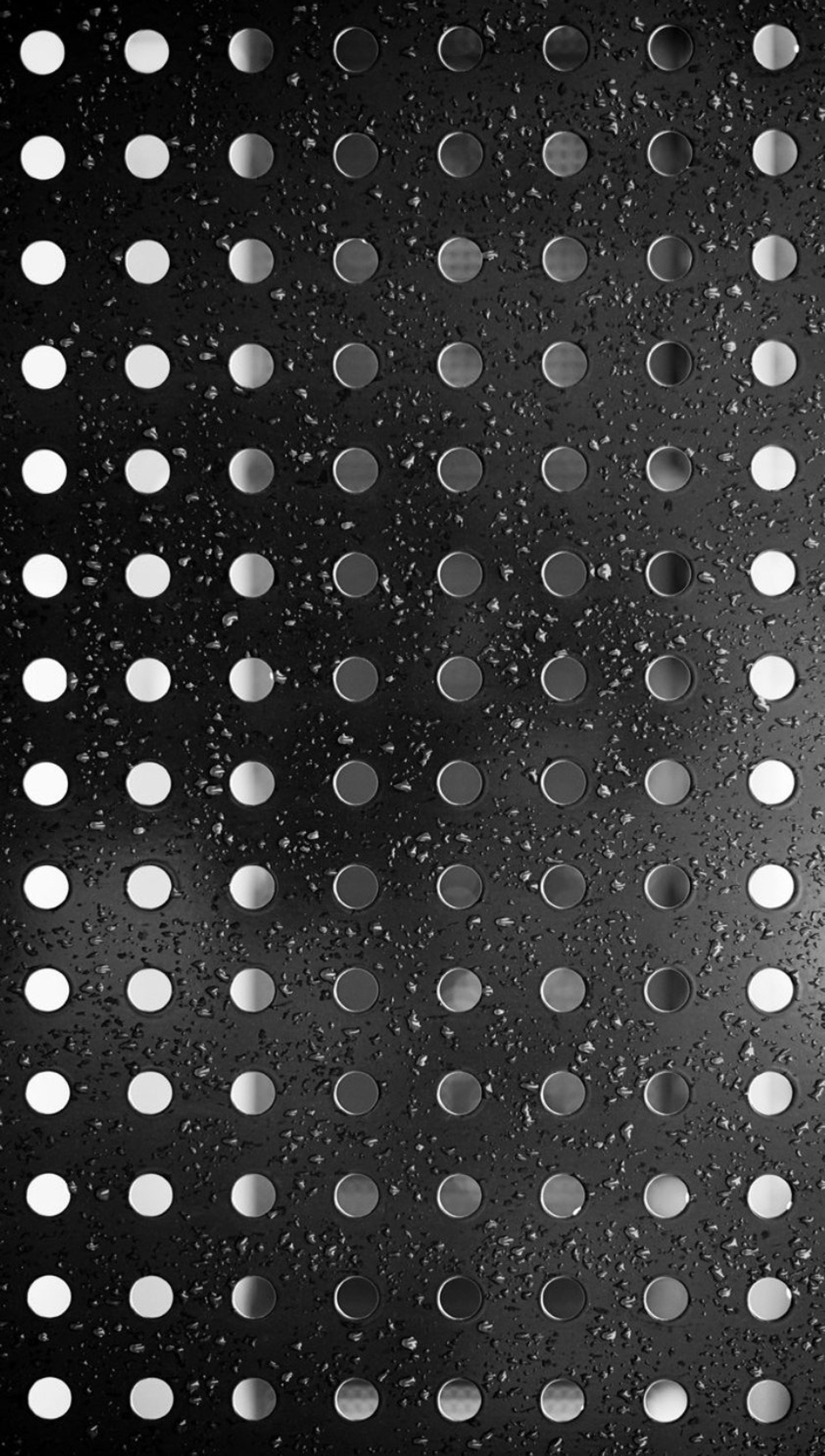 A close up of a black and white photo of a rain covered floor (abstract, background, holes)