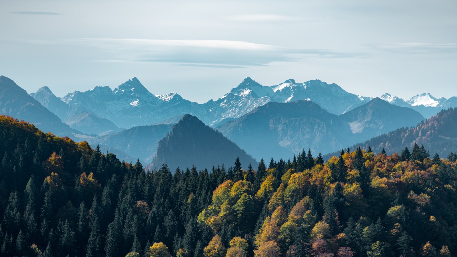 Uma vista das montanhas e árvores à distância com um fundo de céu (floresta, montanha, cenário, natureza, paisagem)