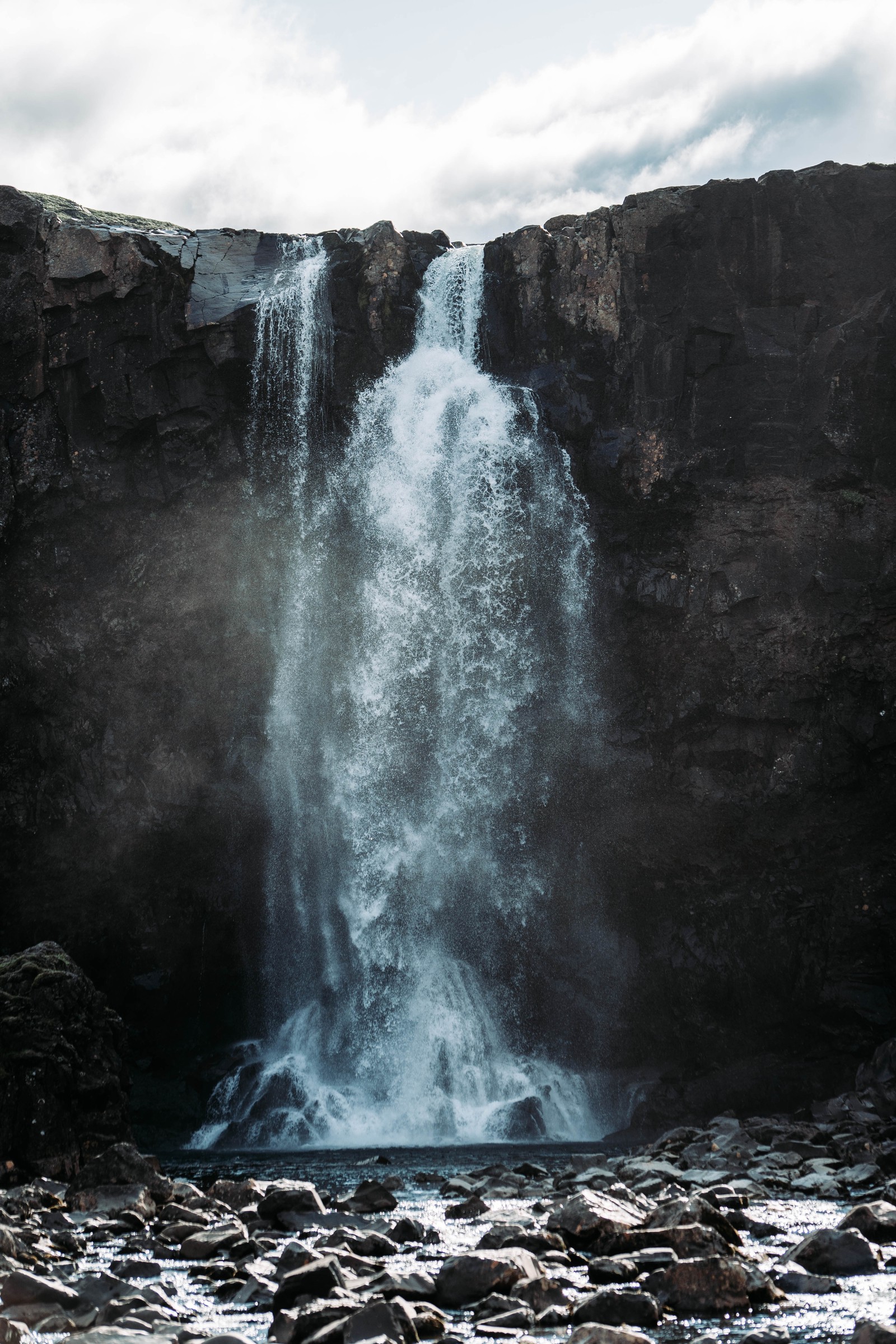 Hay una cascada que fluye sobre rocas en el agua (cascada, cuerpo de agua, recursos hídricos, agua, naturaleza)