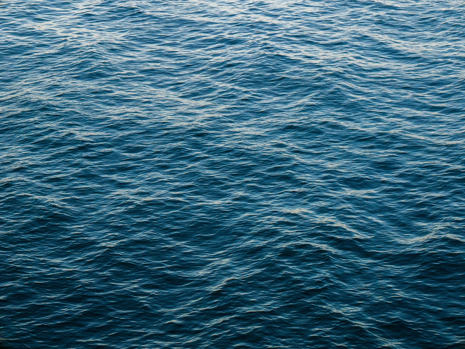 Vue aérienne d'un plan d'eau avec un bateau au loin (bleu, eau, mer, océan, aqua)