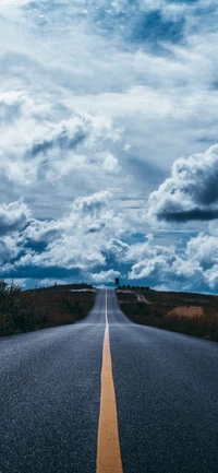 Estrada sem fim sob nuvens cúmulos em uma paisagem natural