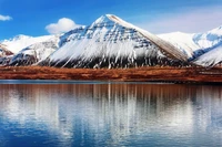 Reflexo de montanha coberta de neve em um lago sereno