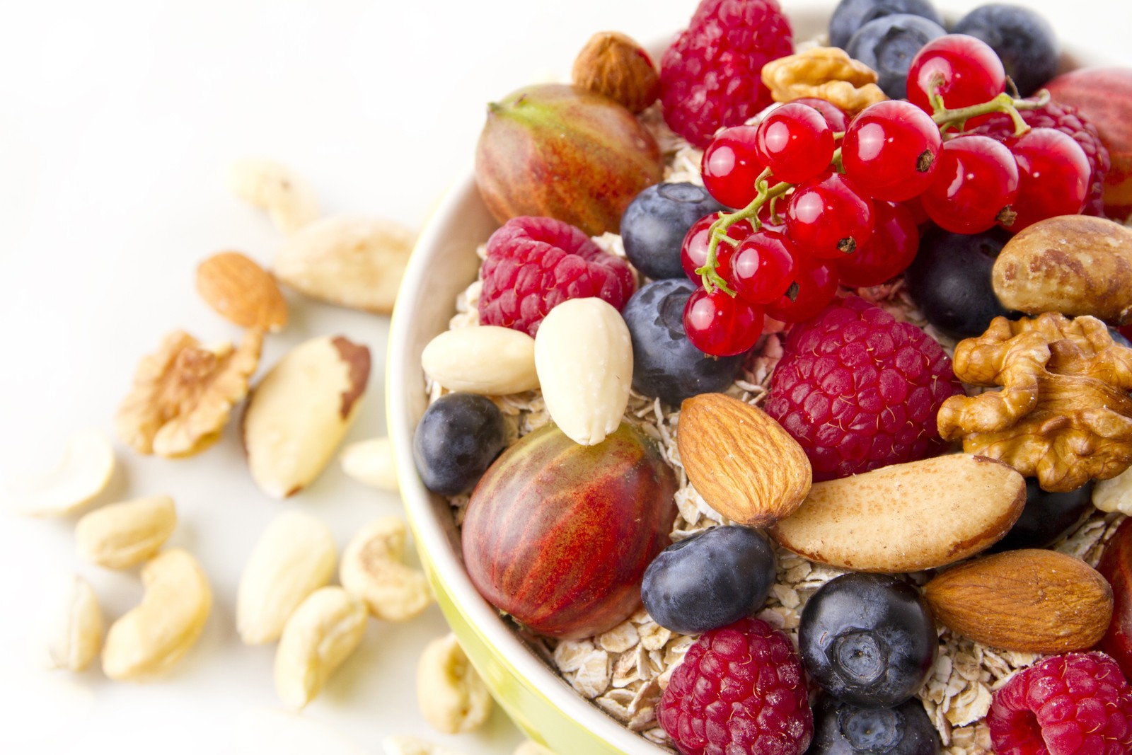 A close up of a bowl of fruit and nuts on a table (snack, breakfast, natural foods, food, breakfast cereal)