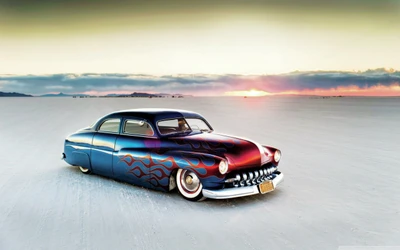 Custom Classic Car with Flames Against a Sunset Background