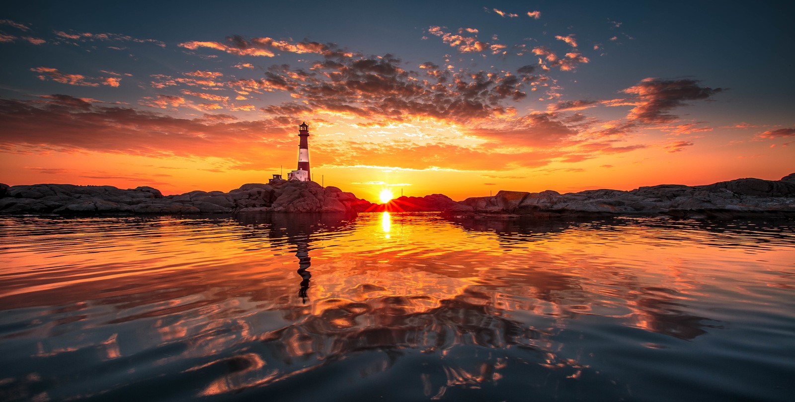 Uma vista de um farol ao pôr do sol com um corpo d'água (resplendor, por do sol, horizonte, nascer do sol, reflexo)