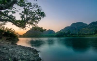 Paisagem de rio tranquila ao crepúsculo com reflexos e vegetação exuberante