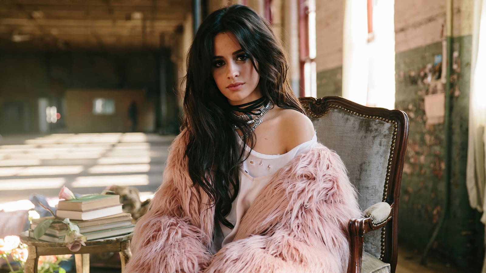 Mujer árabe sentada en una silla con un abrigo rosa (camila cabello, estadounidense, cantante, celebridad, mujeres)