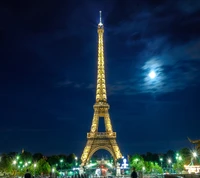 Eiffel Tower Illuminated Under a Moonlit Sky in Paris