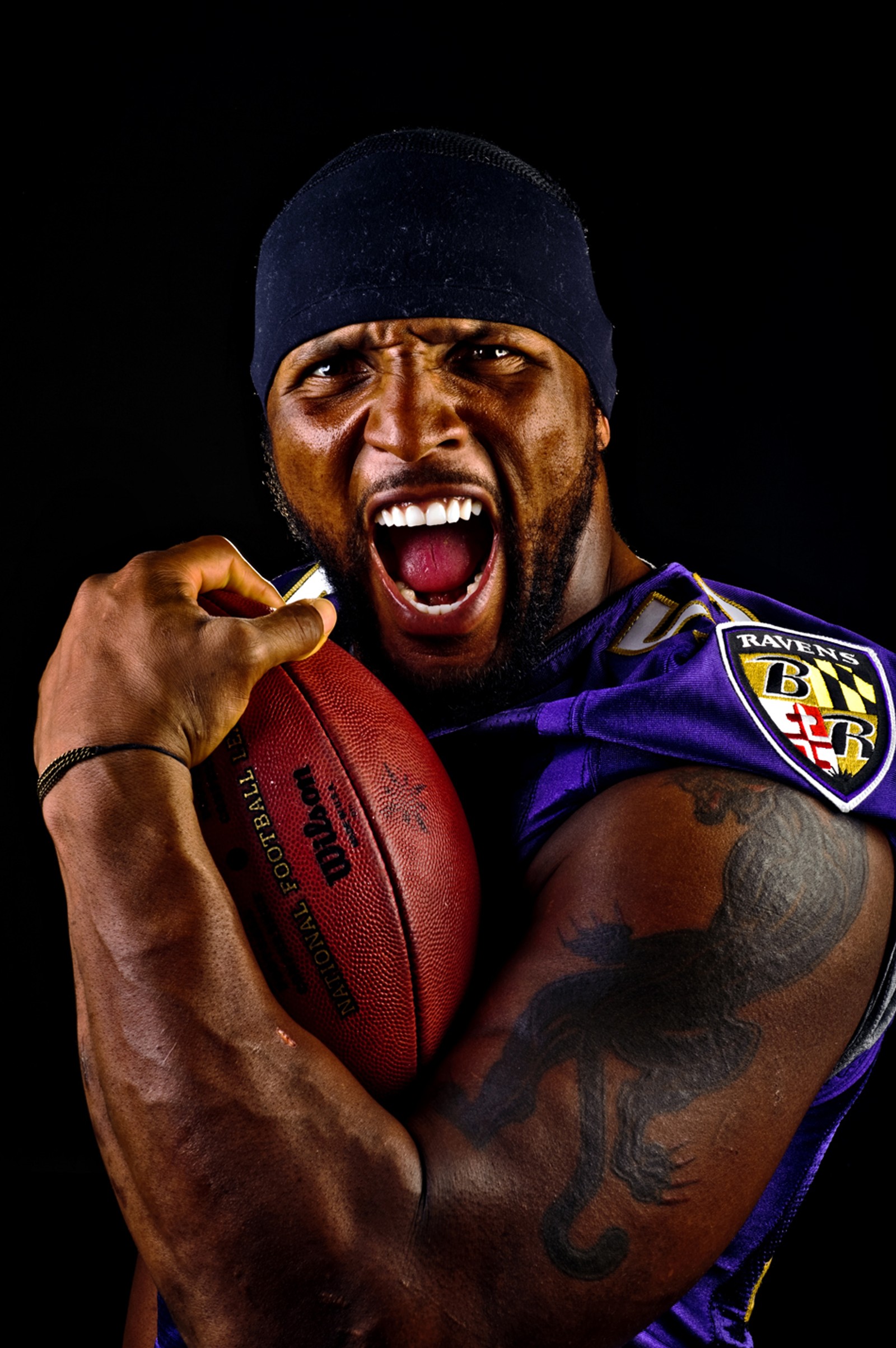 Un homme arabe tenant un ballon de football dans sa main droite (52, baltimore ravens, football, muscle, ray lewis)