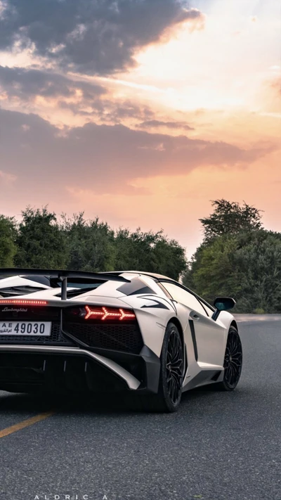 Lamborghini Aventador branco ao pôr do sol em uma estrada aberta