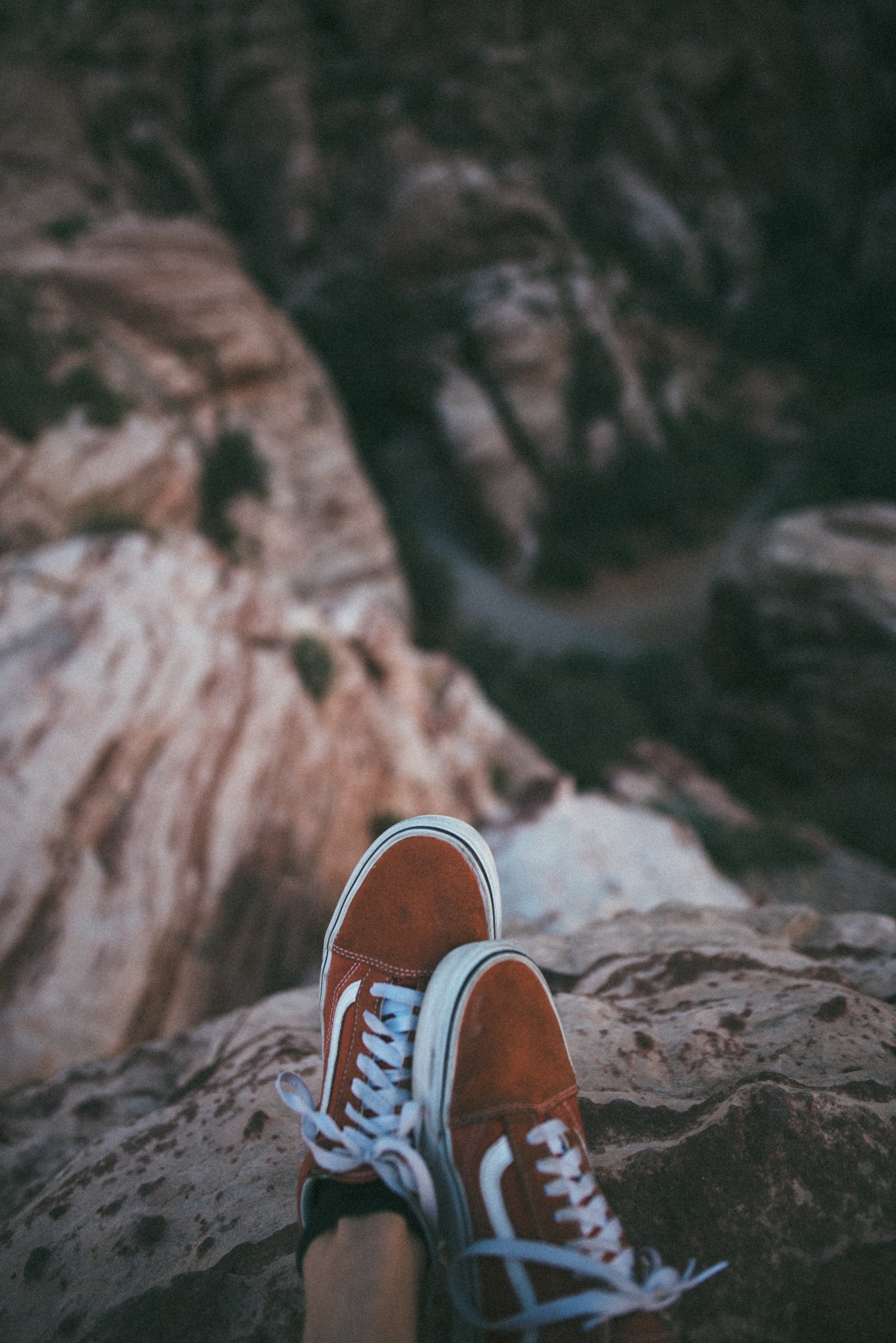 Someone is sitting on a rock with their feet up (shoe, footwear, cool, human leg, brown)