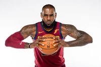 LeBron James in a Cleveland Cavaliers jersey, poised with a basketball, showcasing athleticism and intensity.