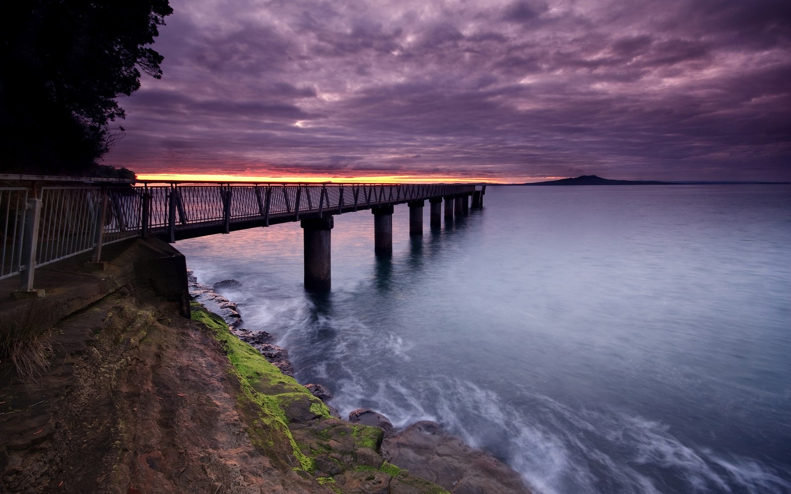 Arafed view of a pier with a bridge over the water (water, nature, sea, cloud, reflection)