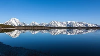 Majestuosa cordillera de las Montañas Grand Teton reflejada en las serenas aguas del Lago Jackson