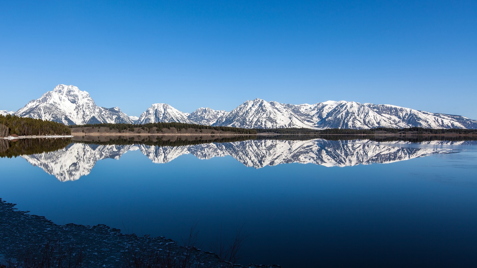 Uma vista de um lago com montanhas ao fundo (grand teton, parque nacional de yellowstone, yellowstone national park, cadeia de montanhas, montanha)