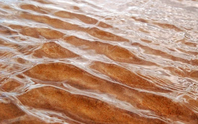 Ondas de agua marina sobre la playa de arena