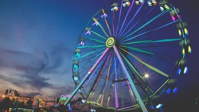 Grande roue colorée illuminée contre un ciel crépusculaire, capturant l'essence du plaisir et de la récréation lors d'un événement de loisirs.