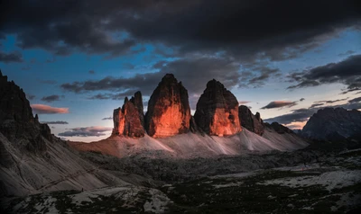 Majestuosa cadena montañosa al anochecer con cielos dramáticos