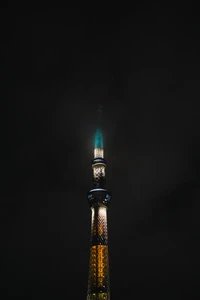 Torre iluminada perfurando o céu noturno