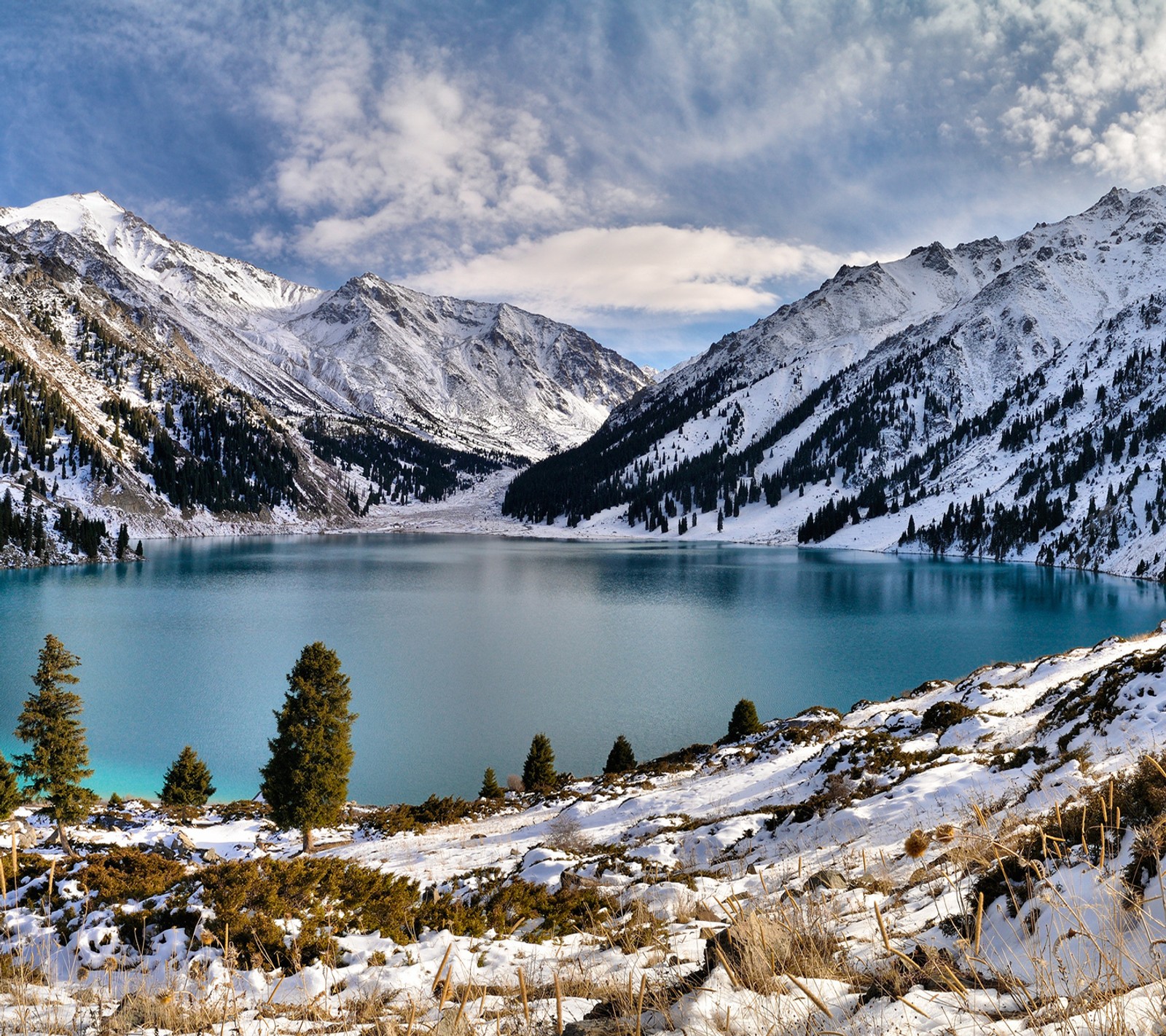 Vue aérienne d'un lac entouré de montagnes couvertes de neige (bleu, lac, neige, eau, hiver)