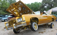 Chevrolet Impala Lowrider dorado personalizado con capó elevado