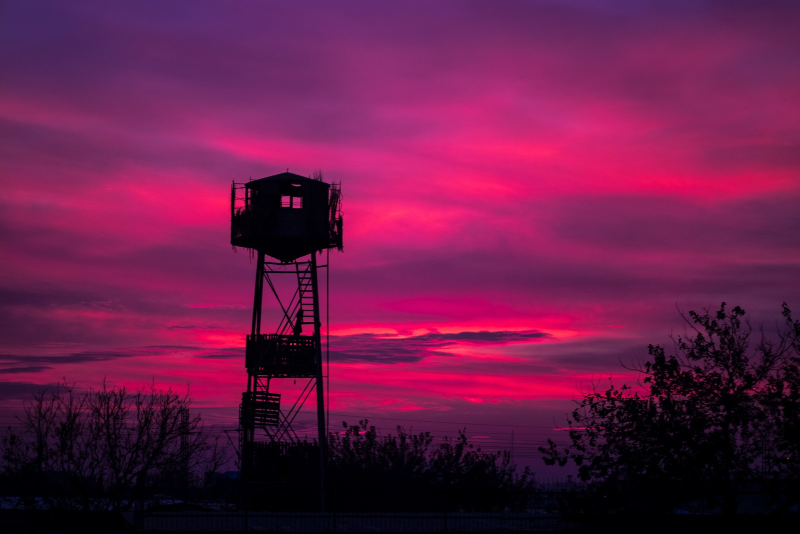 Arafed tower with a clock on top of it at sunset (sunset, red, afterglow, cloud, purple)