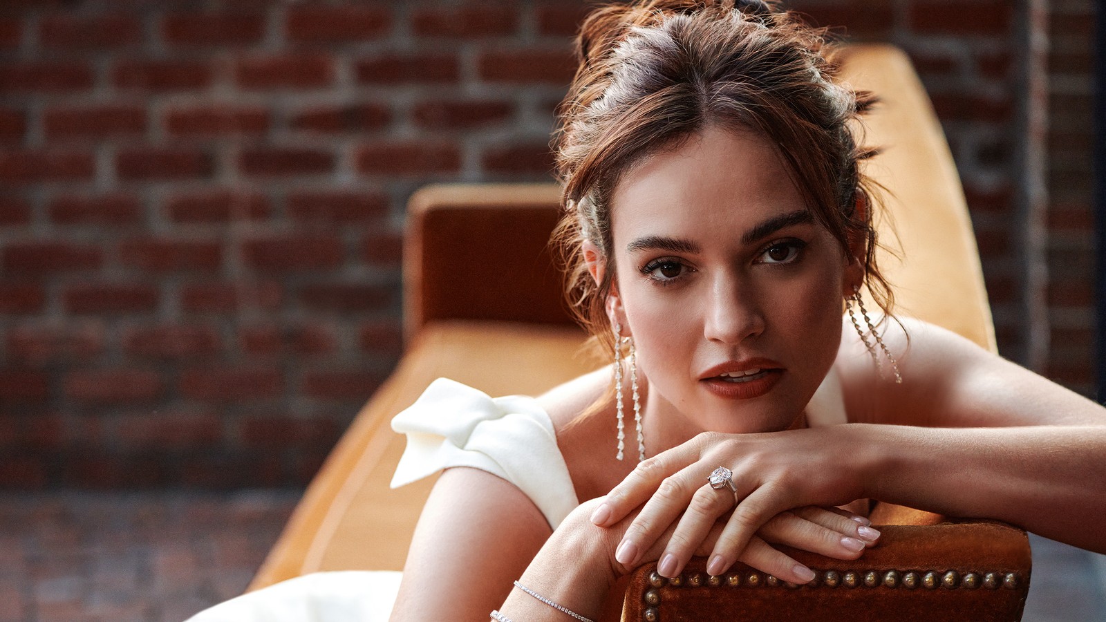 Une femme arabe en robe blanche assise sur une chaise avec les mains sur son menton (lily james, gros plan, 5k, portrait, gens)