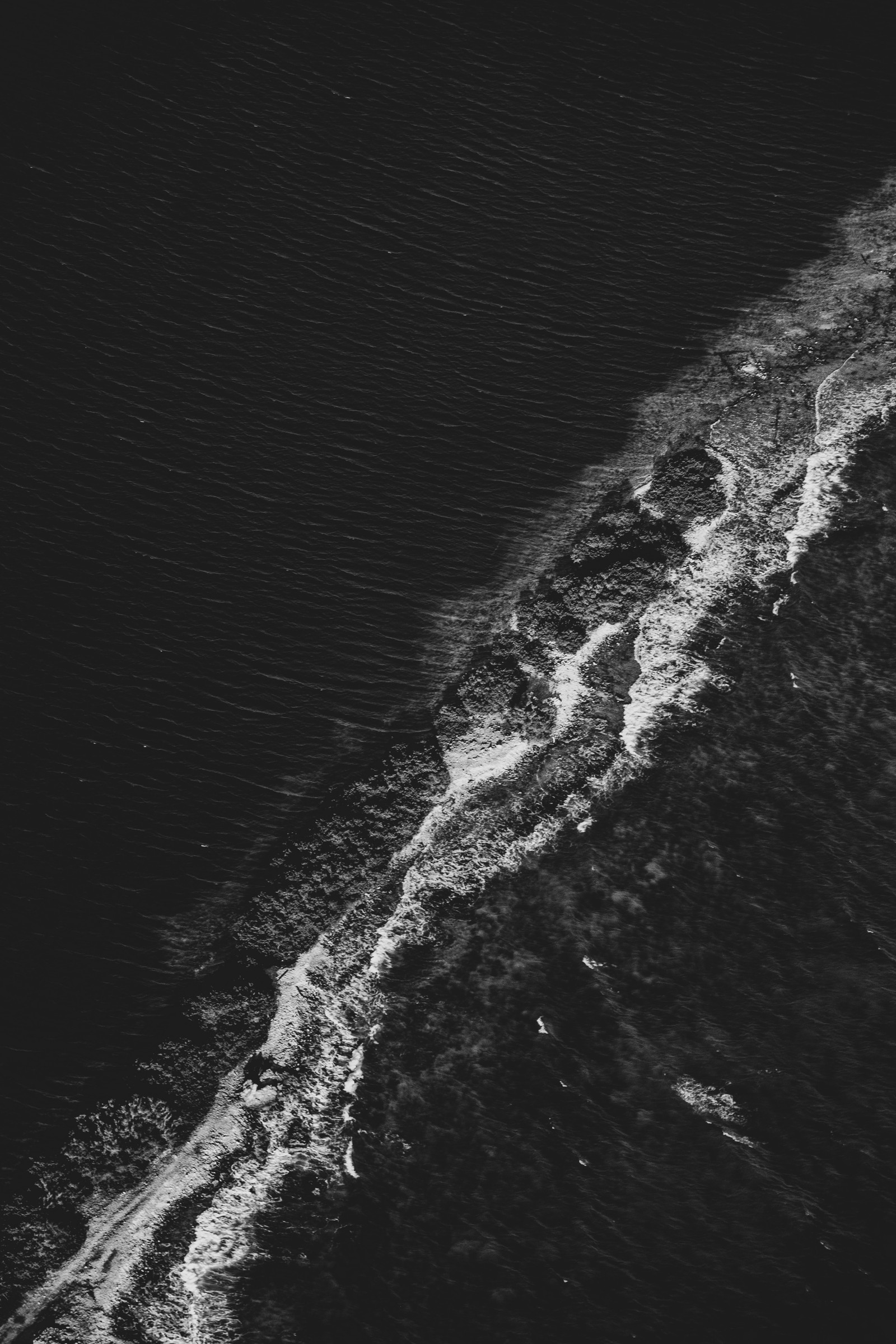 Uma vista de um barco navegando na água perto de uma praia (atmosfera da terra, preto, água, atmosfera, mar)