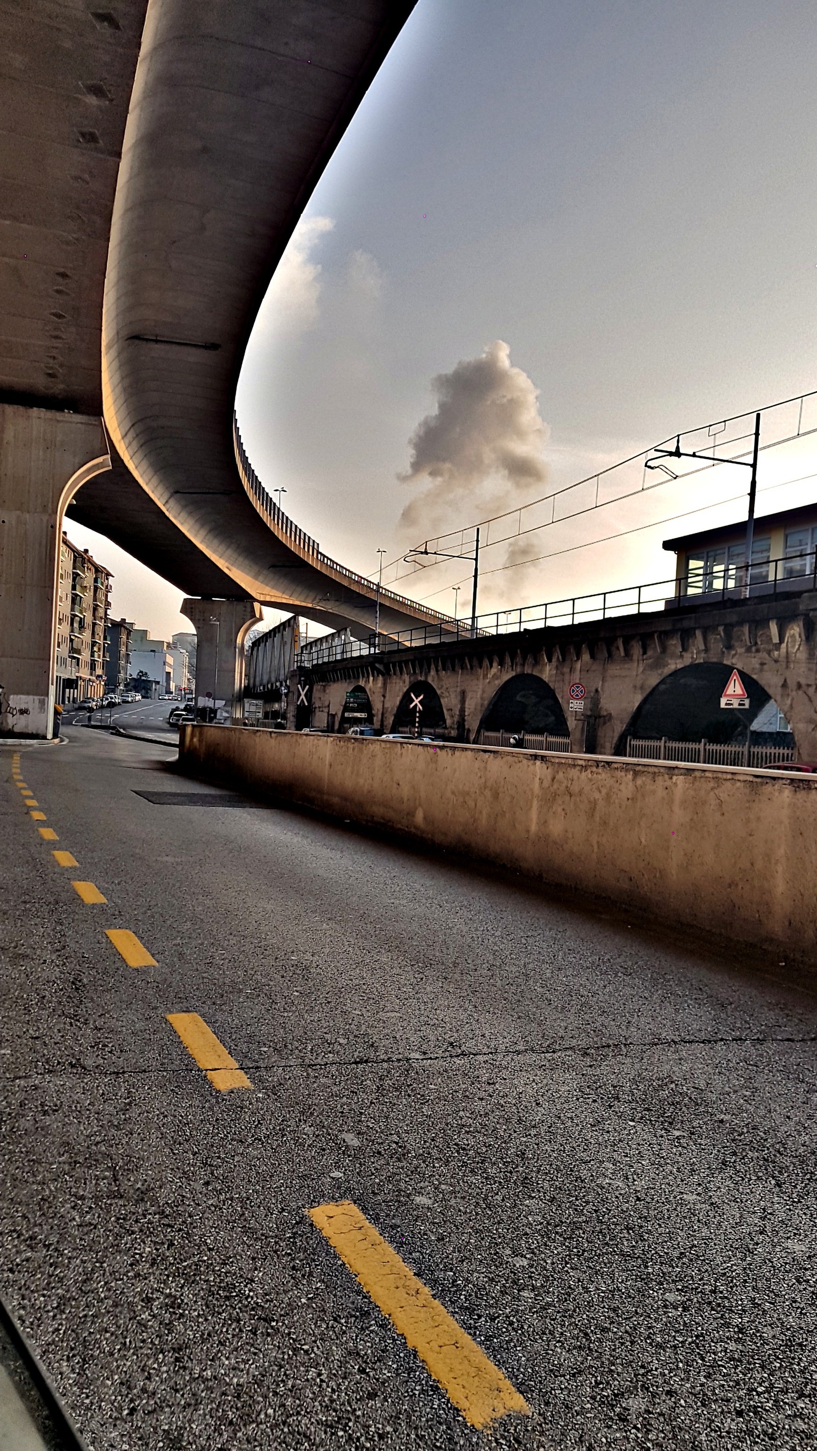 Ein zug fährt auf den schienen unter einer brücke hindurch. (city autumn, dezember, notiz, s6, samsung)