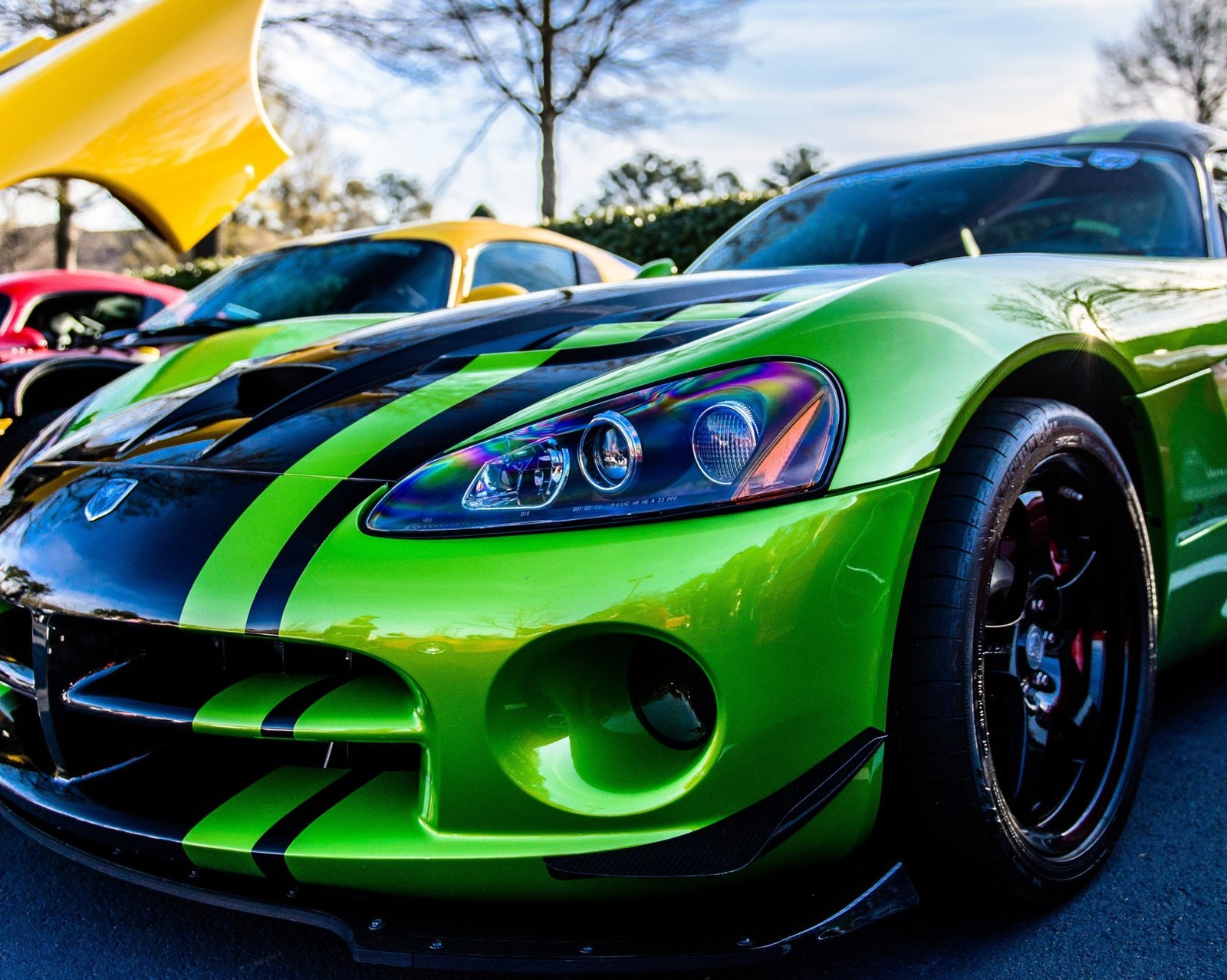 A close up of a green sports car parked in a parking lot (car, green car, race, speed)