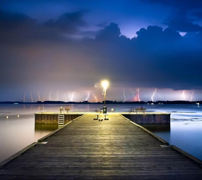 Noite tempestuosa: relâmpagos iluminam o céu sobre um píer