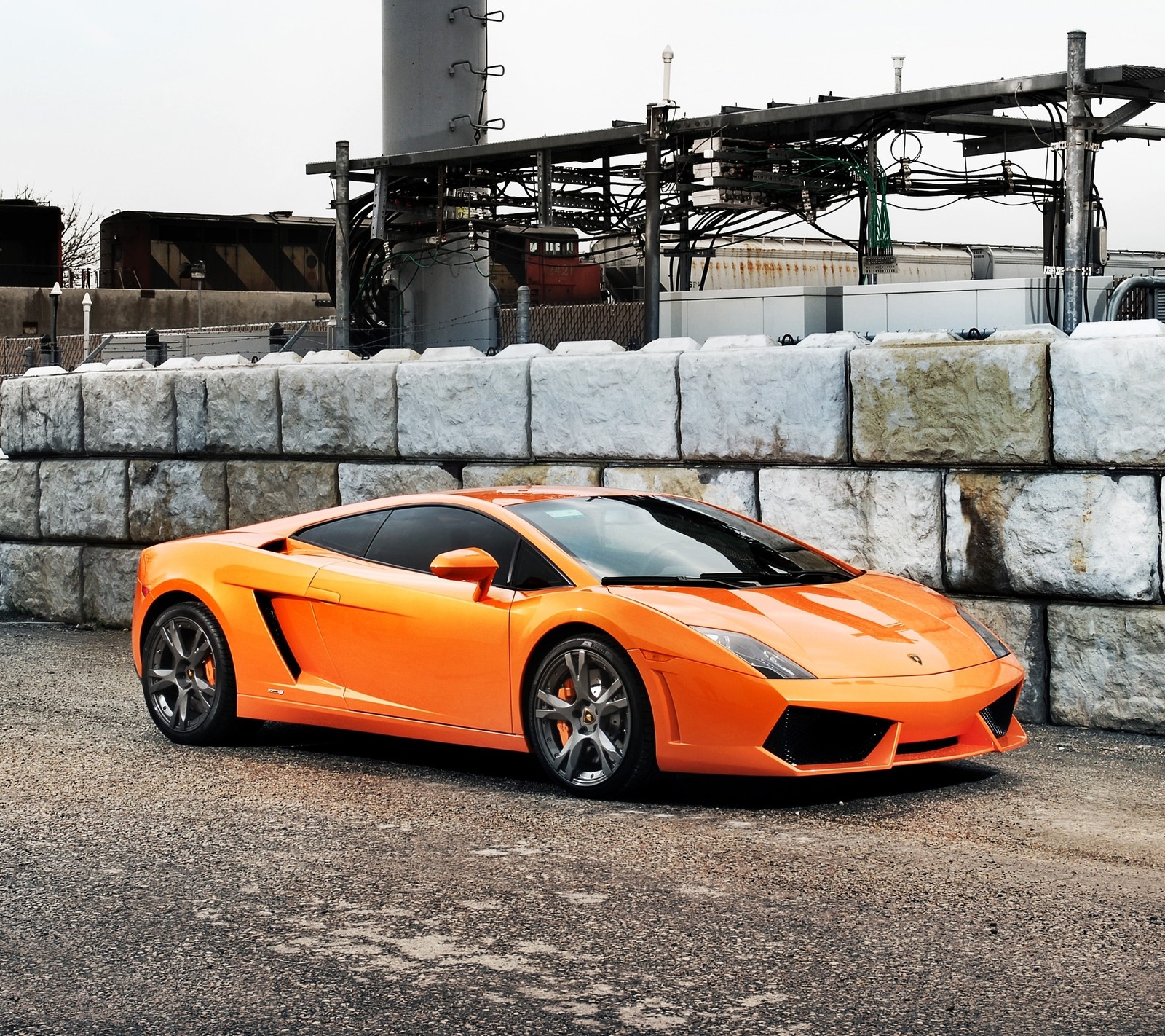 A close up of a orange sports car parked in front of a wall (automobile, gallardo, lamborghini, supercar)