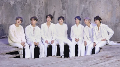 Membros do BTS em trajes brancos posando juntos em um ambiente artístico