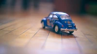 Blue Volkswagen Beetle Toy Car on Wooden Floor