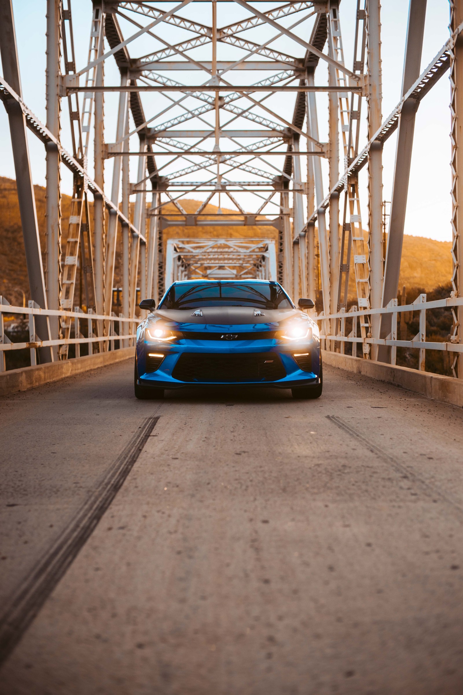 Vista de un coche azul conduciendo por un puente (chevrolet camaro, coche, chevrolet, coche deportivo, exterior de automóvil)