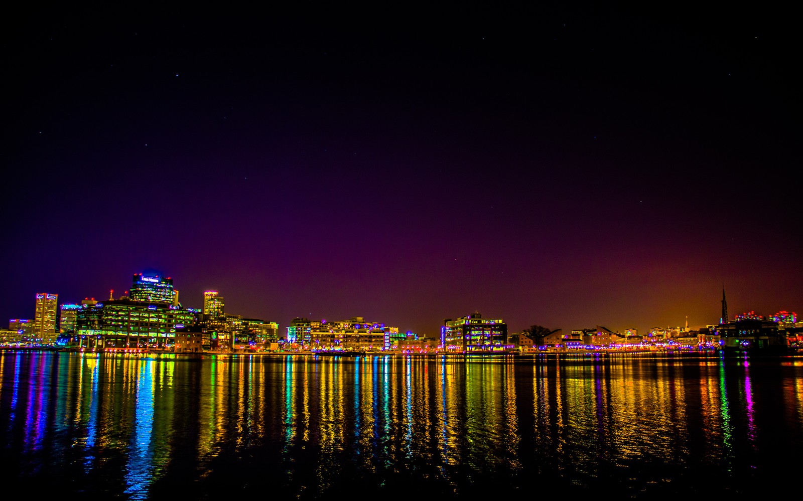 Uma vista do horizonte da cidade à noite com uma luz brilhante refletindo na água (noite, reflexo, paisagem urbana, cidade, metrópole)