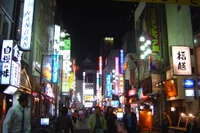 Vida nocturna vibrante en Roppongi: Luces de neón iluminan las calles urbanas de Tokio