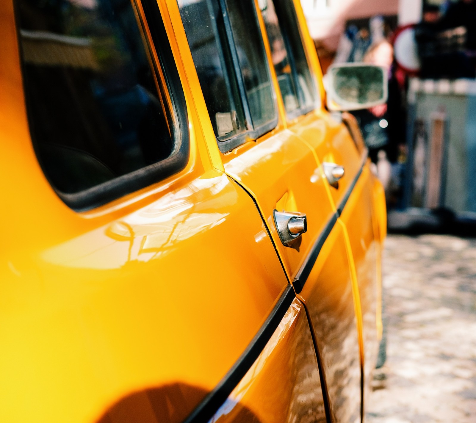 There is a yellow car parked on the side of the street (auto, cab, car, zedgeyellow)