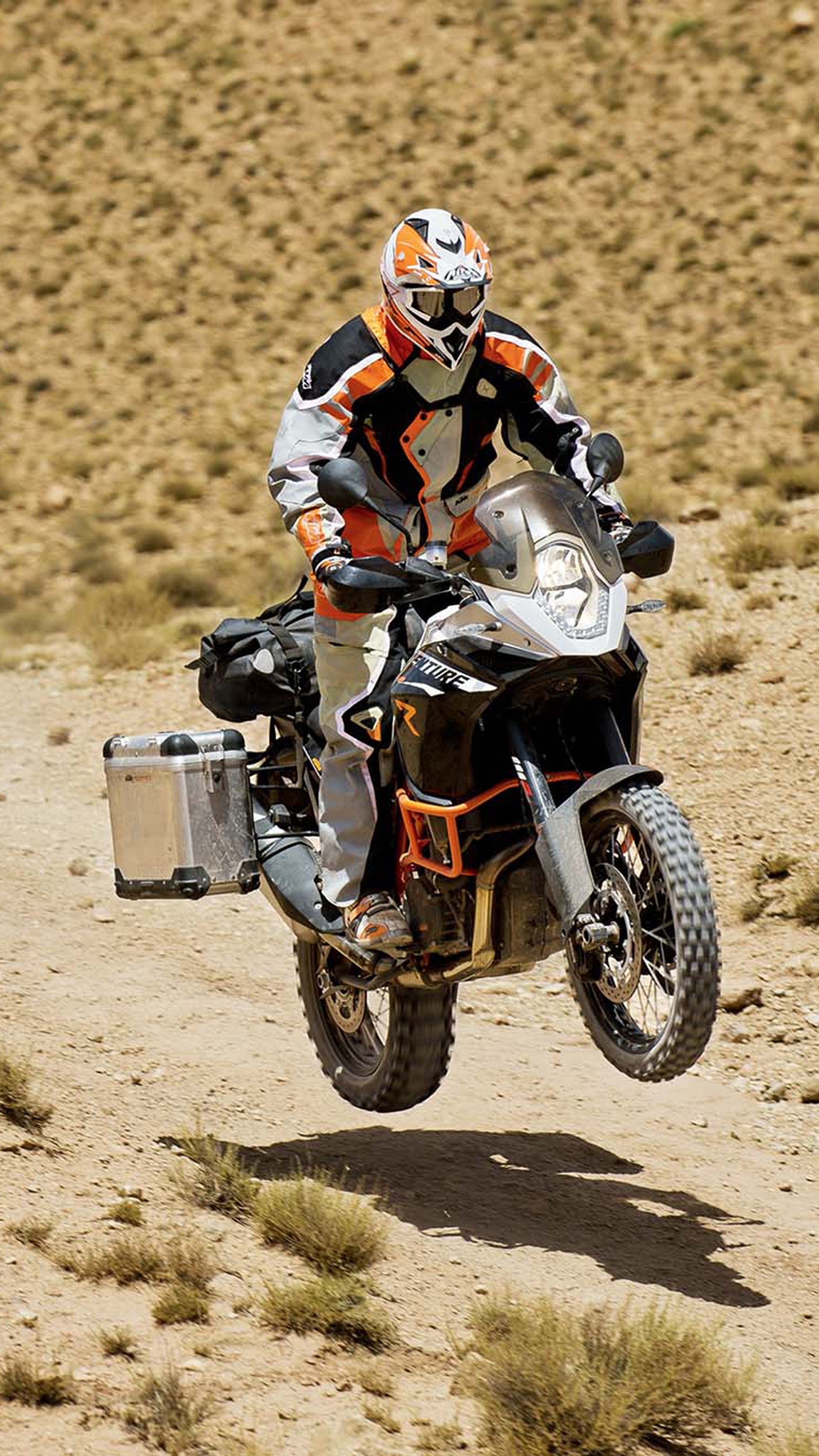 Vista aérea de un motociclista con casco y traje naranja y blanco montando una moto de cross (bicicleta, ktm, naranja, velocidad)