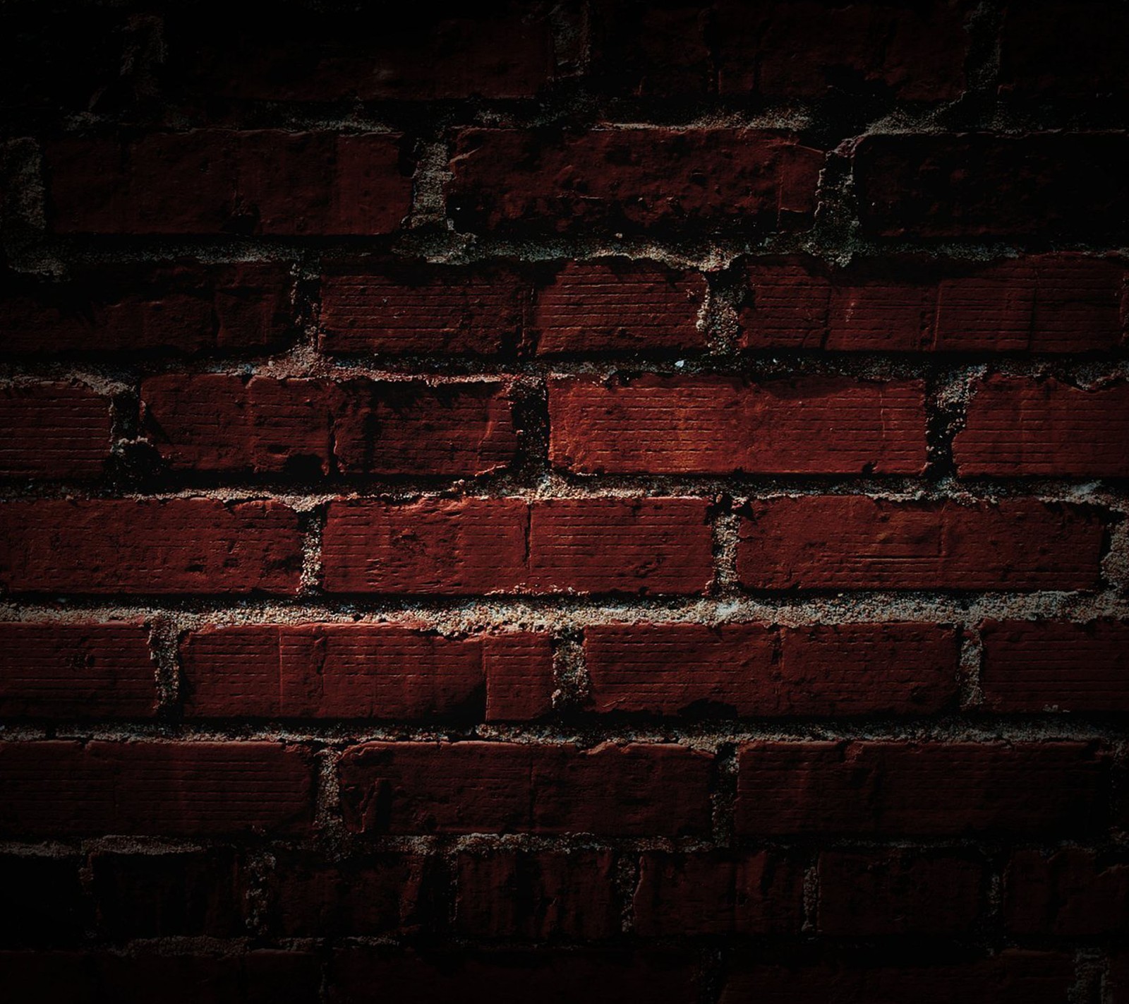 Un mur en briques rouges sur fond noir (briques, mur)