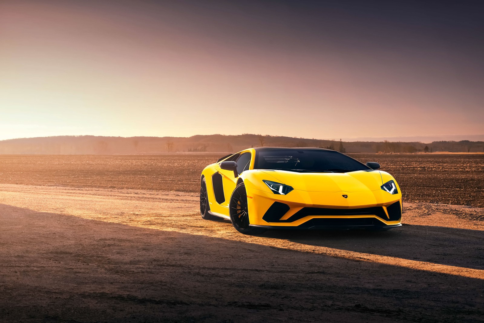 Un coche deportivo amarillo conduciendo por un camino de tierra en el desierto (lamborghini, italia, supercoche, amarillo)