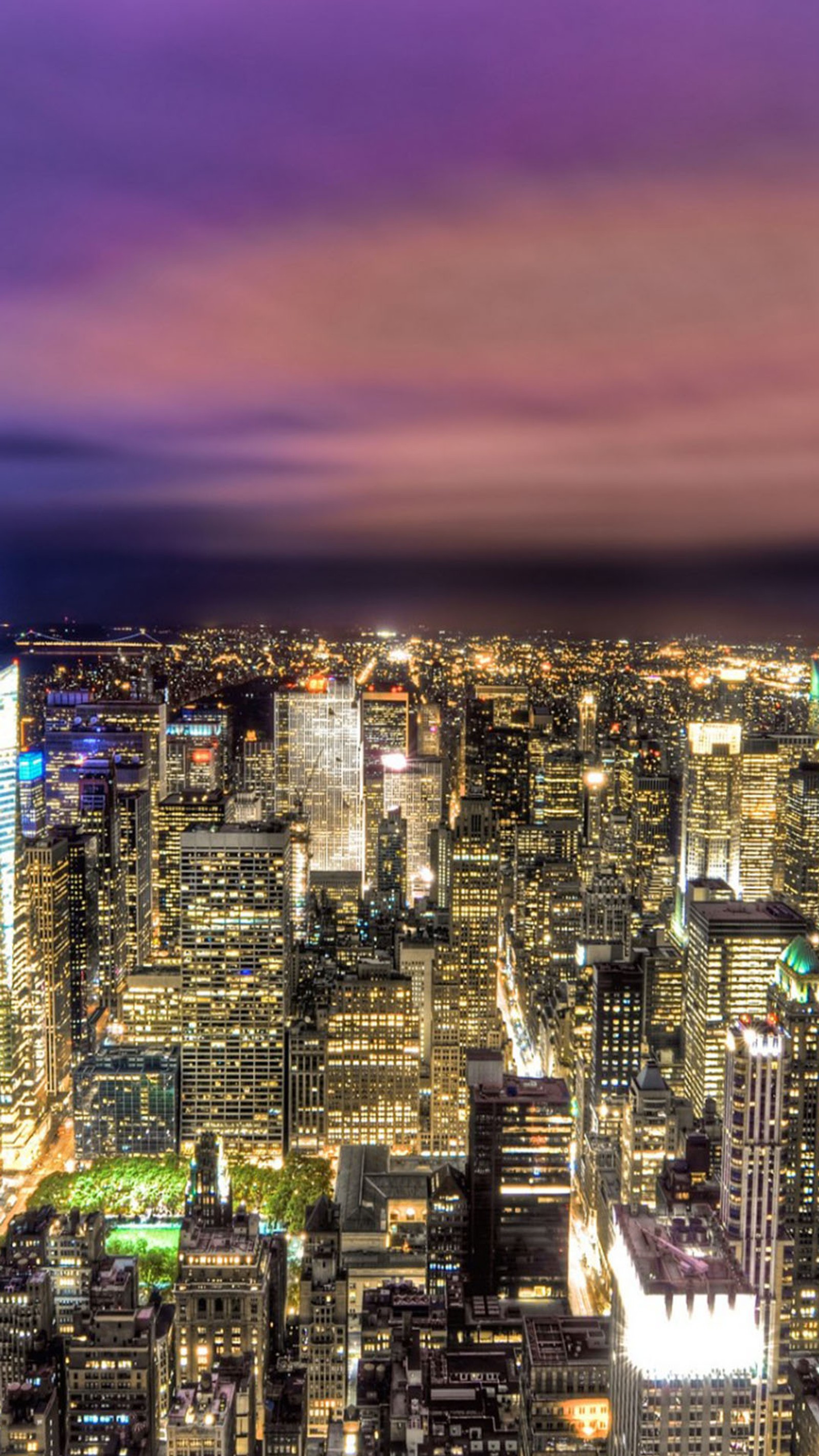 Vista de uma cidade à noite com um céu roxo. (luzes, noite)