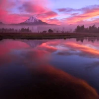 Serener See mit Reflexion unter einem lebhaften rosa Himmel