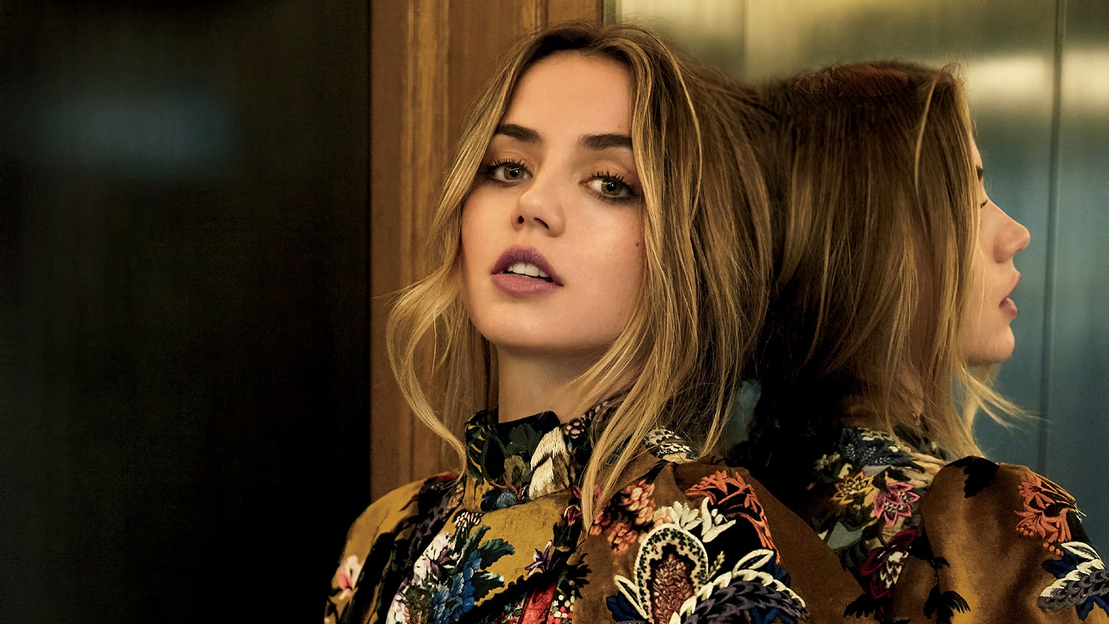 Uma mulher árabe com cabelo loiro e uma camisa floral olhando no espelho (ana de armas, cubano, espanhol, atriz, celebridade)