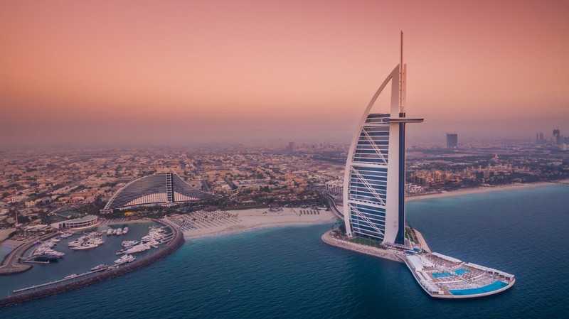 Арафед вид города с лодкой посреди воды (бурдж аль араб, burj al arab, джумейра, jumeirah, курорт)