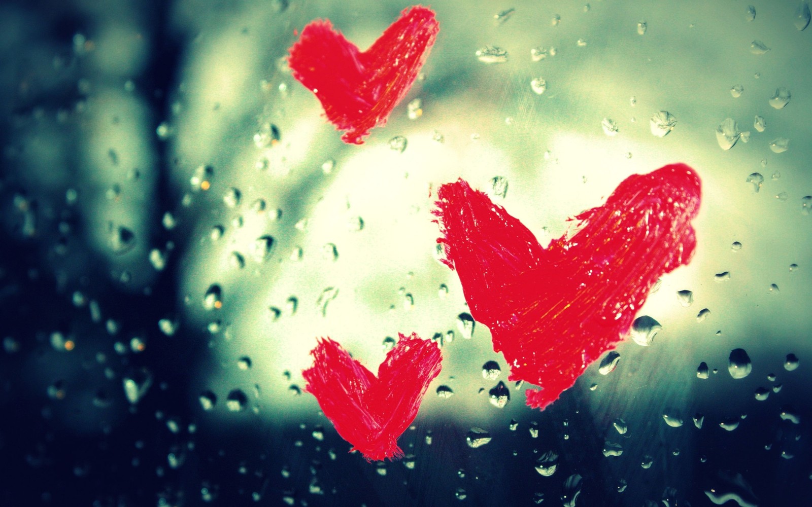 There are two hearts drawn on a window glass with rain drops (heart, leaf, love, petal, valentines day)