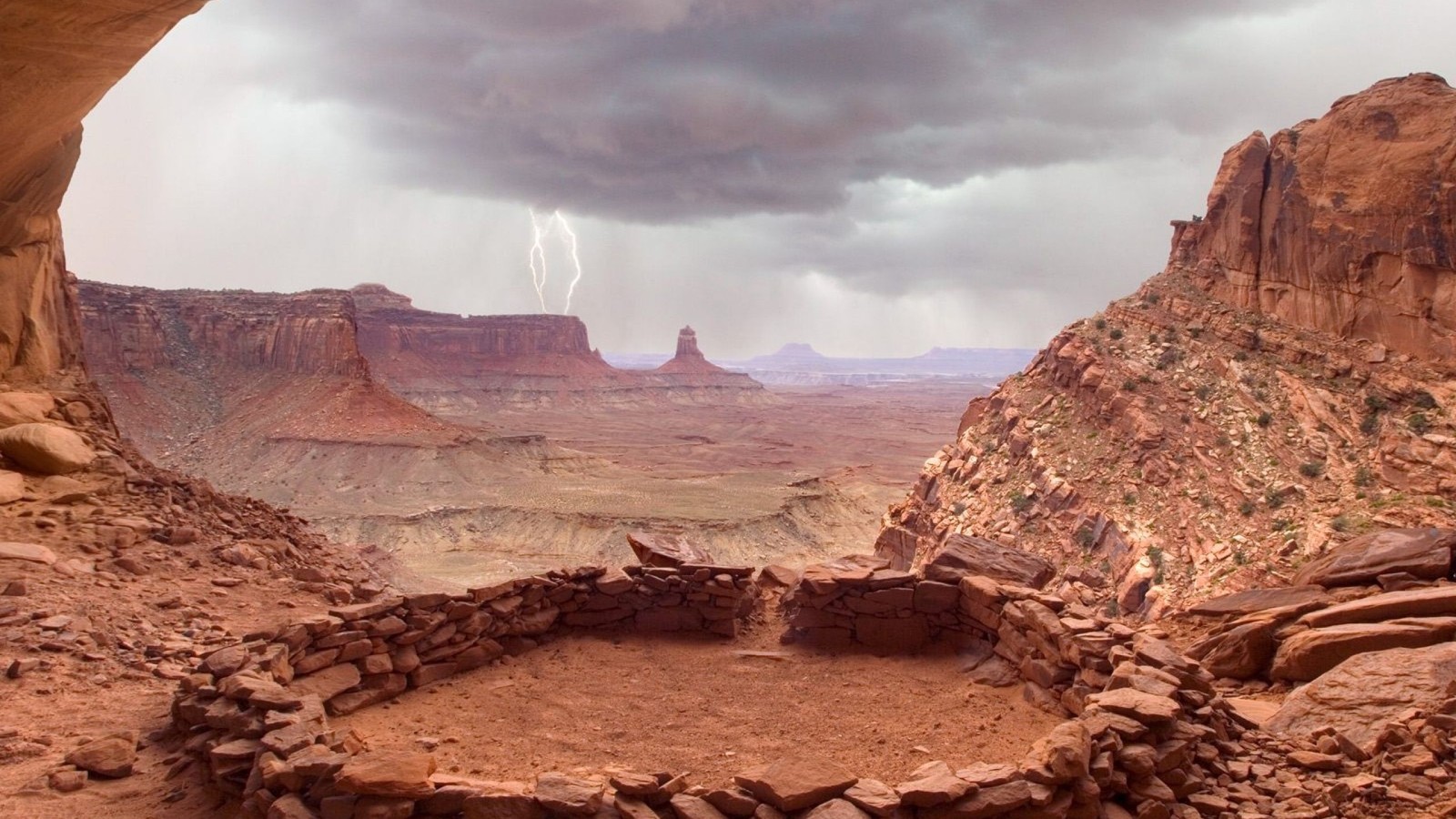 Uma vista de uma área desértica com uma estrutura de rocha e um relâmpago (parque nacional, parque, wadi, cânion, formação)