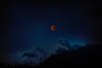 Luna llena iluminada sobre majestuosas montañas bajo un cielo estrellado