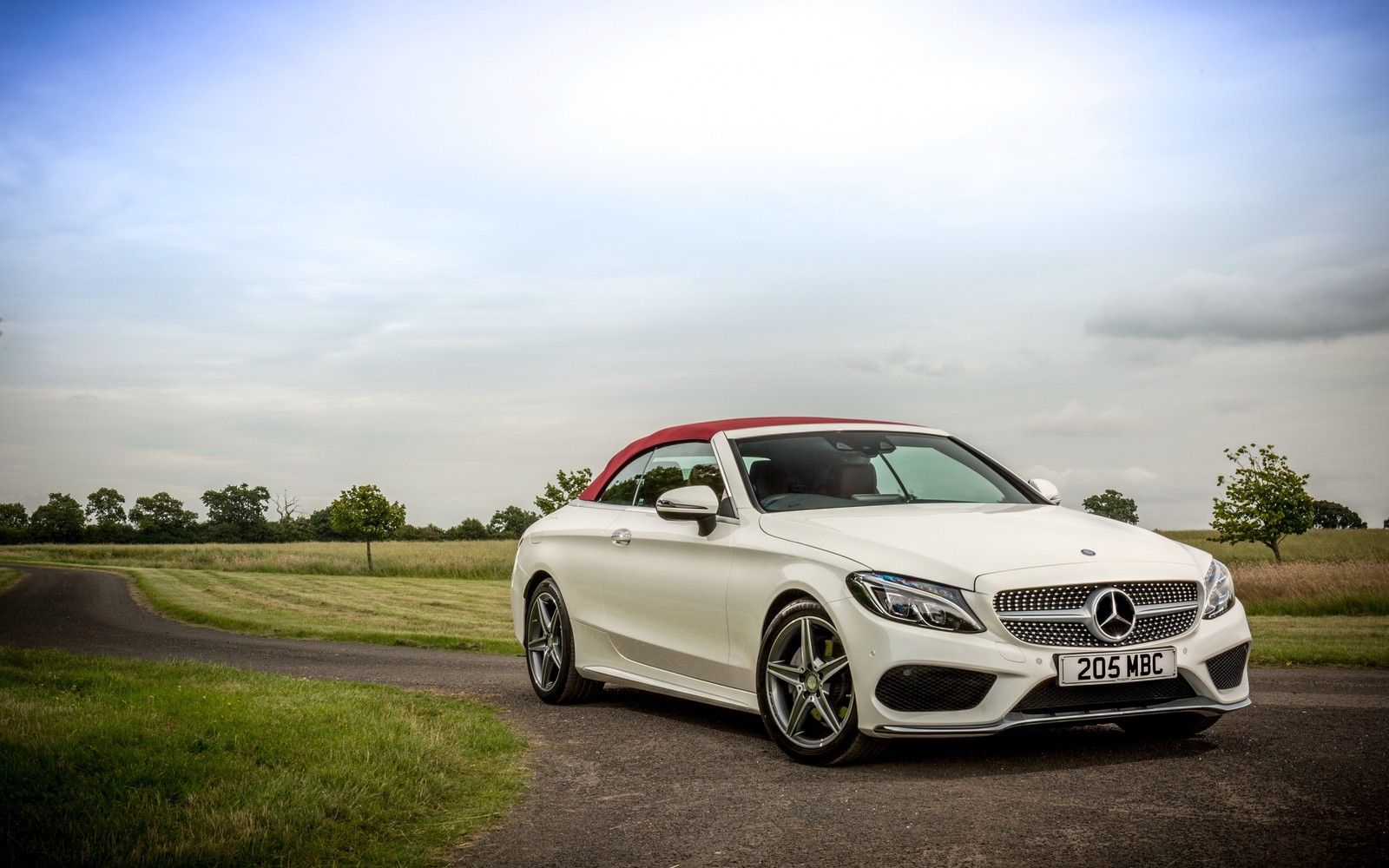 Une mercedes classe s blanche décapotable garée sur une route (mercedes benz e class, voiture, roue, roue en alliage, jante)